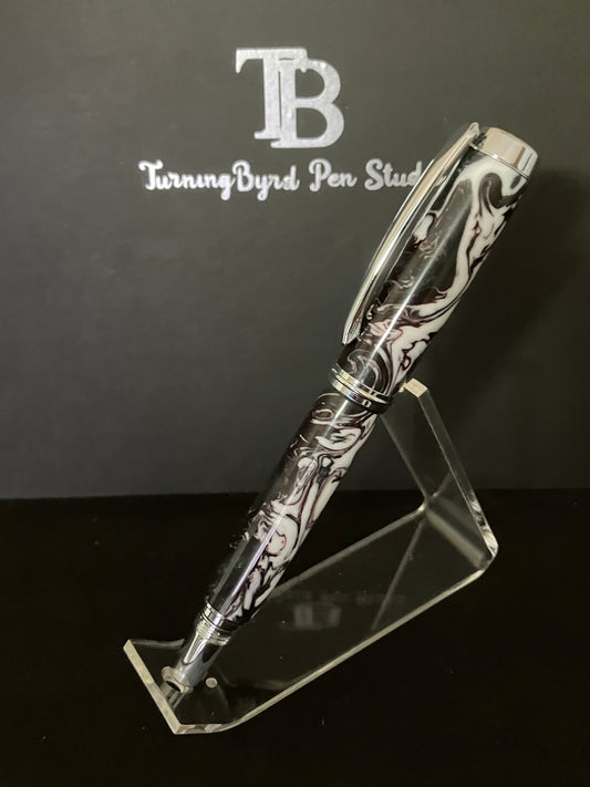 A handcrafted rollerball pen with a dark purple body and white and silver swirl patterns