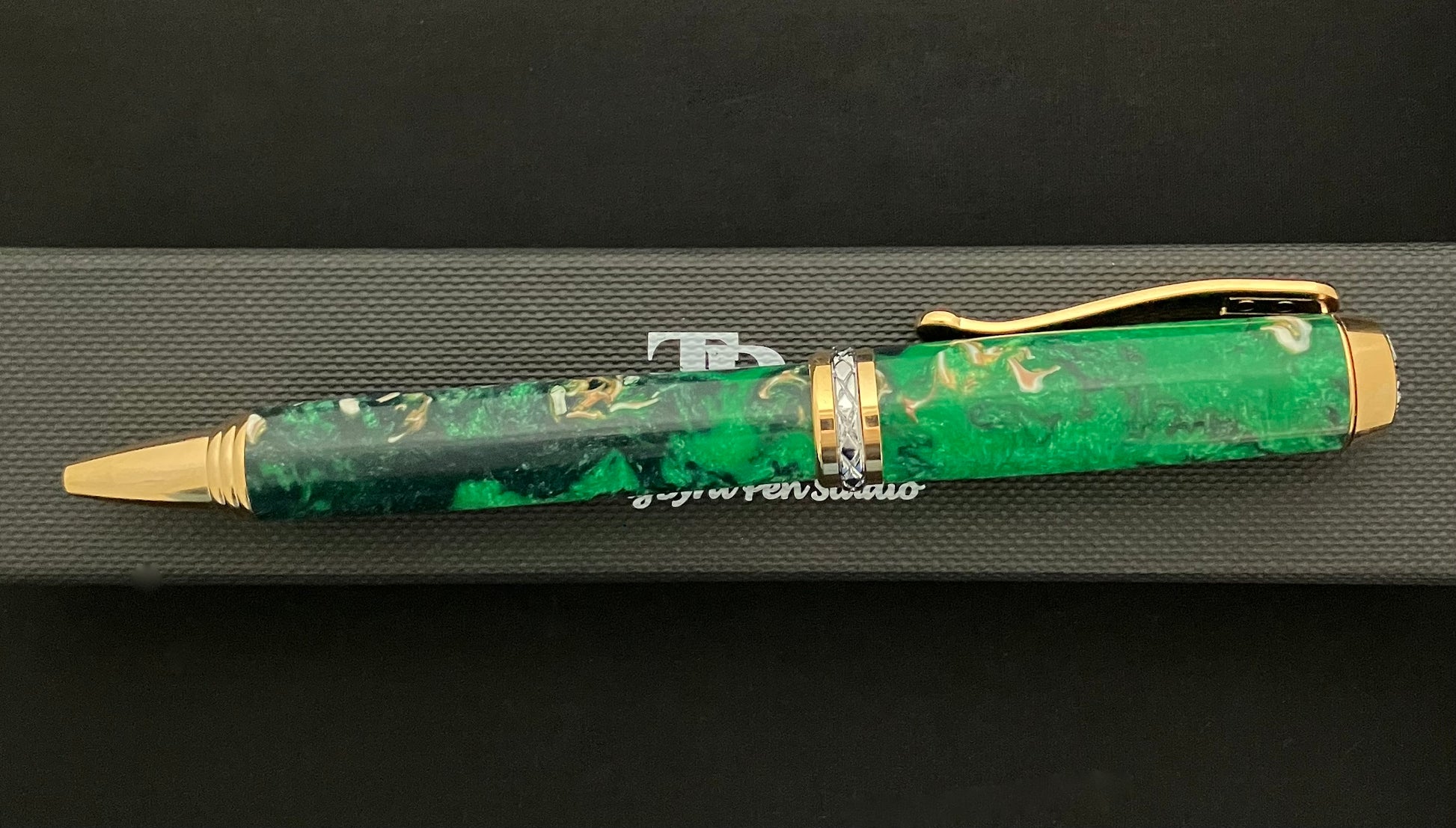 Gold plated twist ballpoint pen with sparkling green resins with bits of sea shells included!