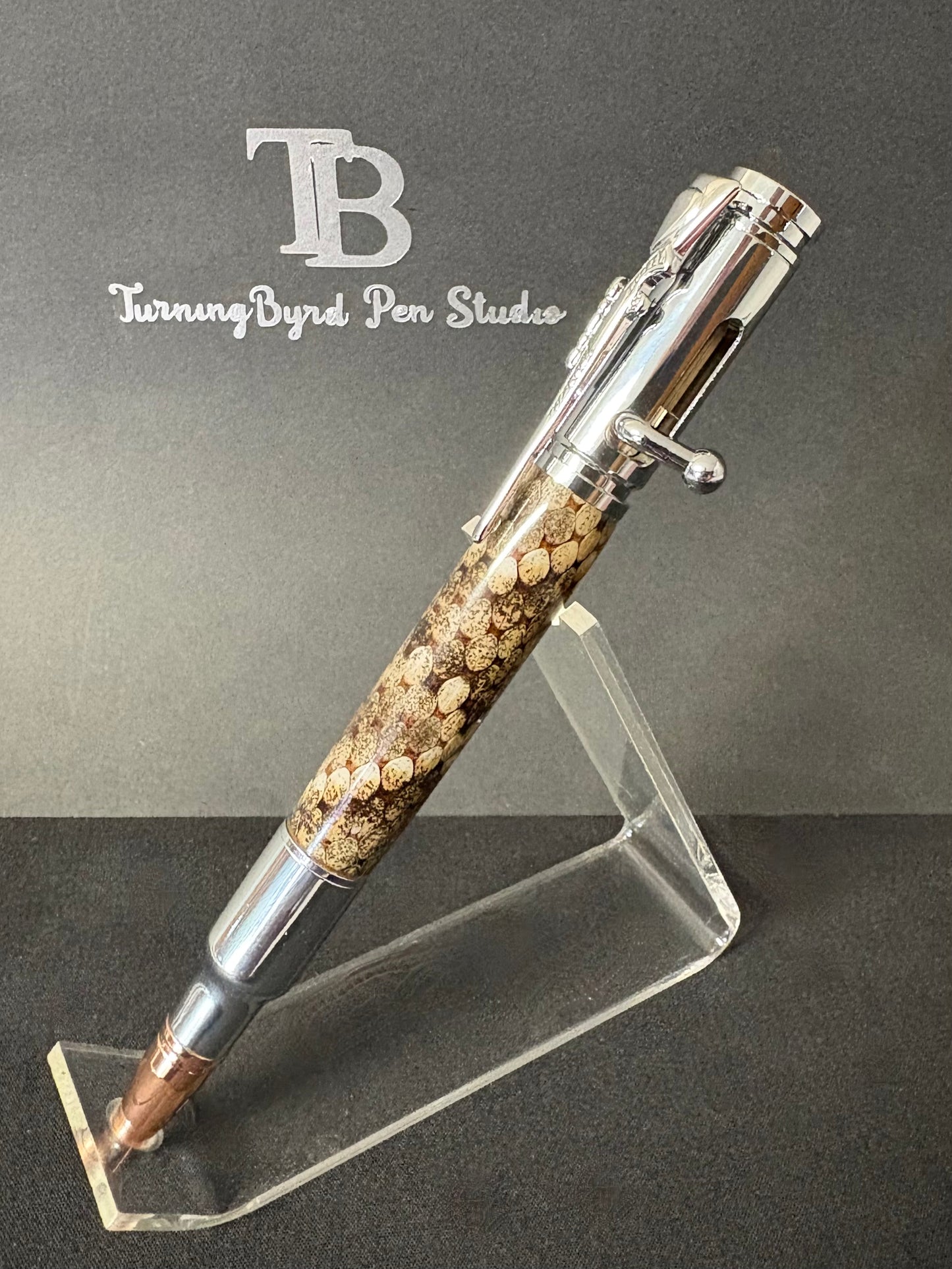 Bolt Action pen on a stand with body of pen made out of rattlesnake skin 