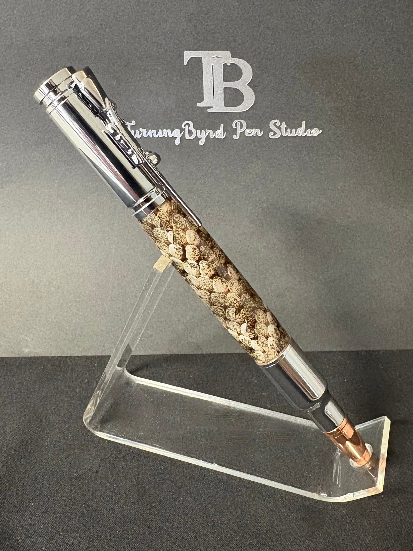 Pen on a stand with 'TB Turning Byrd Pen Studios' branding on a gray background
