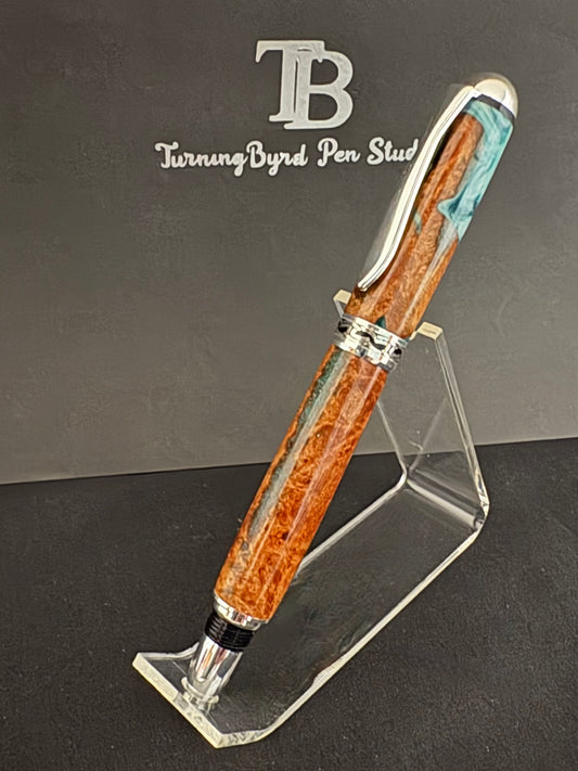 Cherry Burl Wood pen with green and white resin on a clear stand against a gray background with 'TB Turning Byrd Pen Studio' logo.