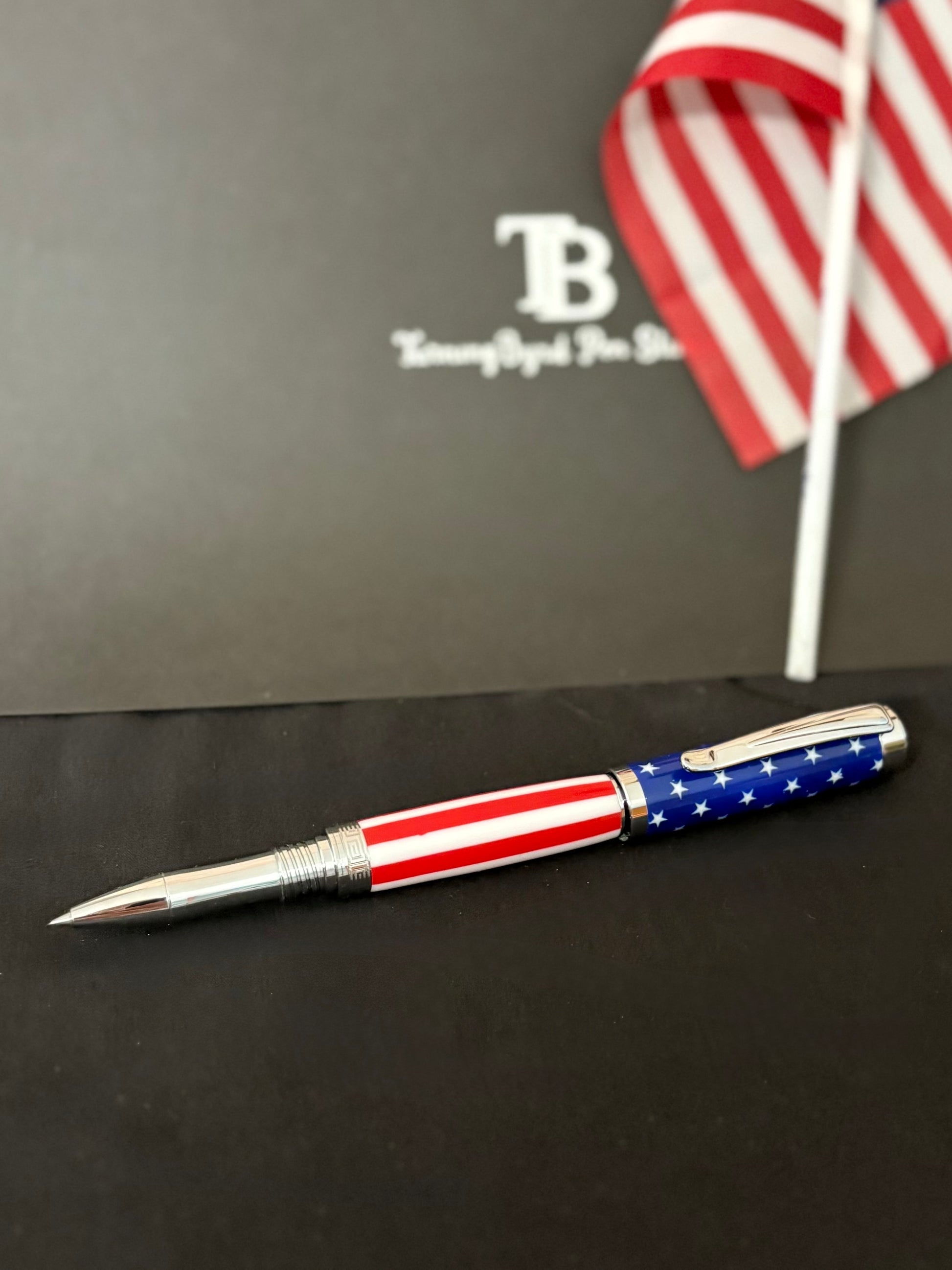 Pen with American flag design on a black surface with a blurred background